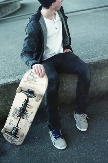 Jesse holding his skateboard at the skatepark